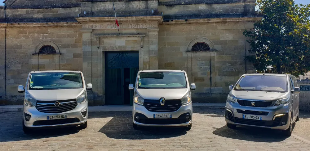 Camions de transport funéraire devant une église